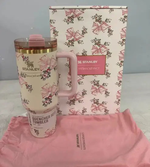 Pink Stanley tumbler with floral design, matching pink pouch, and floral-patterned box on a light gray background. EA Supplements